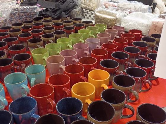 Colorful ceramic mugs stacked on a display table