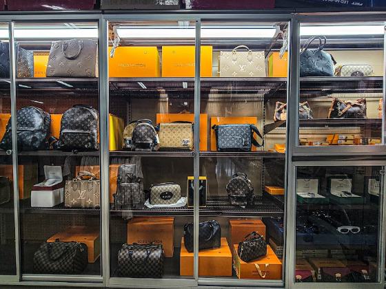 Handbags displayed in a lit glass case