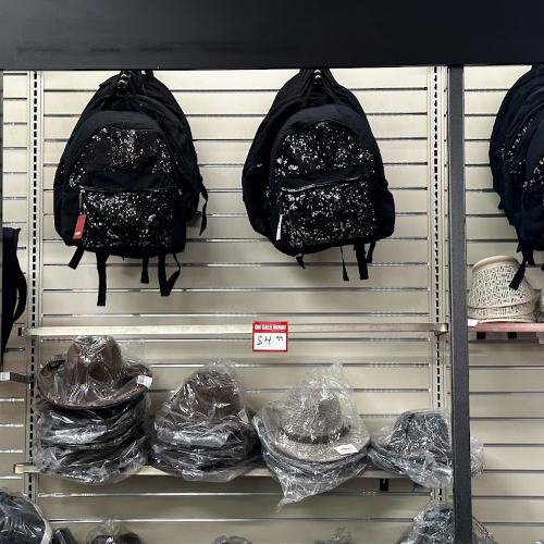 Backpacks and hats hanging on a display wall